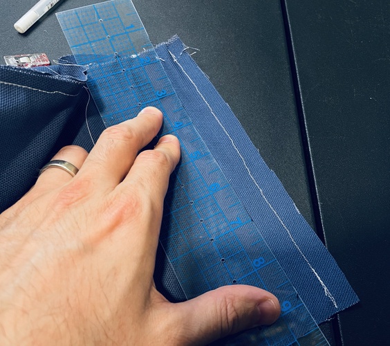 Take those stitches out and pinch the side seam down to where it’s an even fit with the base. Then mark that point and re-stitch the side panel. Trim the excess and then sew the base back down again.