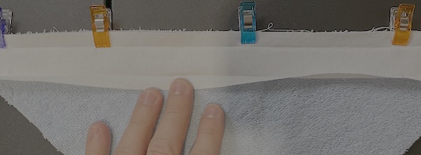 Unfold the bias and line up the raw edge with the raw edge of the terry cloth.