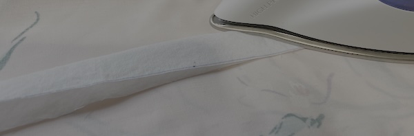 Fold the strip in half lengthwise and iron down.