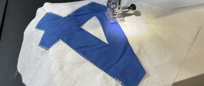 Layer your detail shape over your main fabric, align along the edge of the appliqué shape and sew
