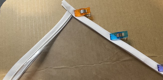 Place the middle fold of the bias tape directly on the edge and clip down