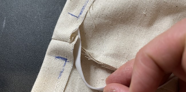 Feed in the elastic, pin, clip or hold the starting end at the beginning of the casing