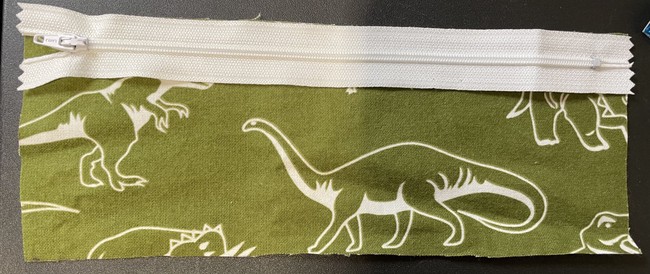 Place the zipper on the top raw edge of one piece of the lining fabric