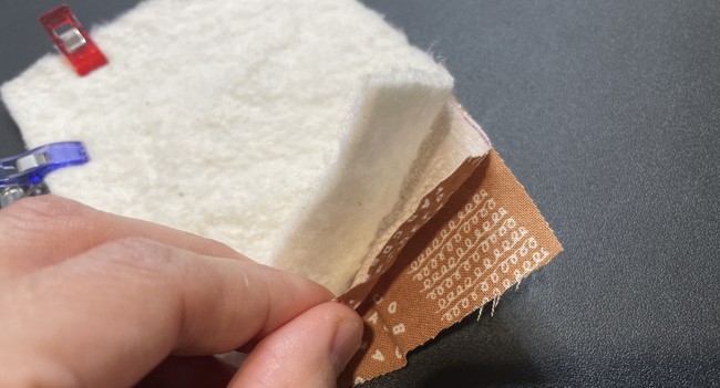 The batting goes on top because when you turn the coffee cup sleeve out it will be on the inside