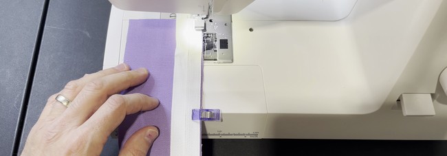 Line up the raw edge of the right side of the zipper with the raw of the right side of the first fabric piece