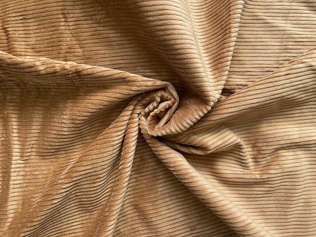 Corduroy is a woven cotton fabric with vertical ridges (called "wales") that give it a distinctive texture